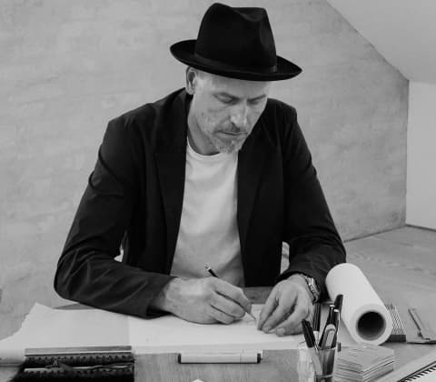 A portrait of Søren Rose sketching in their studio